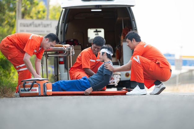 Foto el paramédico está asistiendo a un hombre herido en una situación de emergencia en la carretera