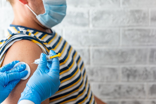 El paramédico le da a un hombre una vacuna contra el coronavirus
