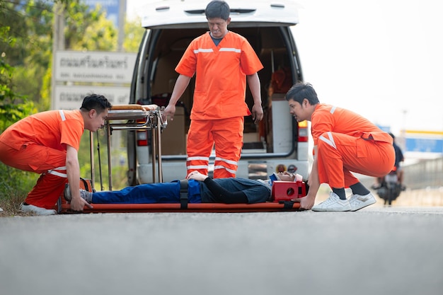 El paramédico está asistiendo a un hombre herido en una situación de emergencia en la carretera