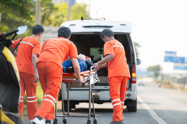 El paramédico está asistiendo a un hombre herido en una situación de emergencia en la carretera