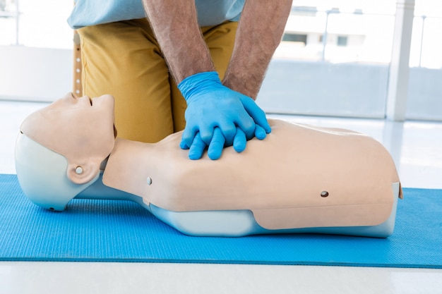 Paramédico practicando resucitación cardiopulmonar en maniquí