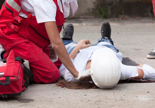 Paramedico realizando reanimação cardíaca em pessoas mulheres na rua