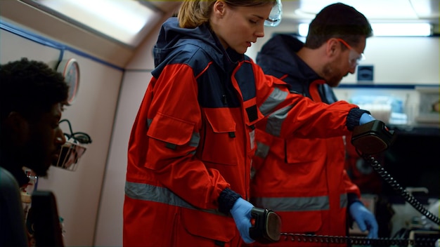 Foto paramédicos de ems preparando el desfibrilador para ayuda médica médicos multiétnicos reanimando a un hombre inconsciente en camillas en el coche de emergencia el personal médico proporciona reanimación a la víctima