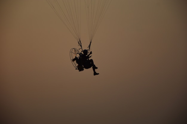 paramotor volando en el fondo del atardecer