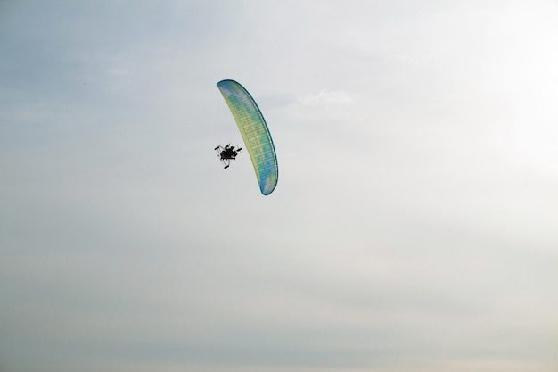 Foto parapente com motor sobrevoa o mar, coberto de gelo e neve