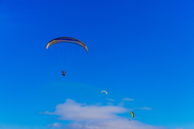 Parapente no céu azul. o paraquedas com parapente está voando. esportes radicais, conceito de liberdade