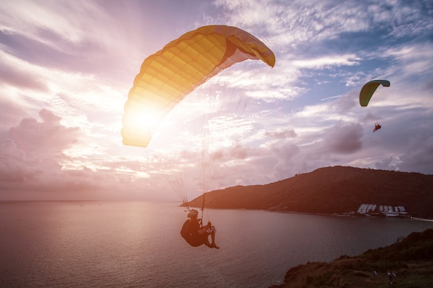 Parapente persiguiendo la puesta de sol en Windmill Viewpoint. Phuket, Tailandia.