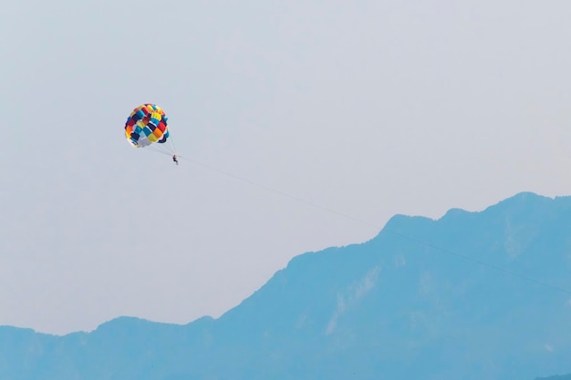 Parapente sobre o mar em um fundo de montanhas