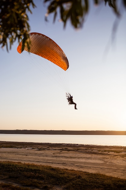 Parapente voando ao pôr do sol