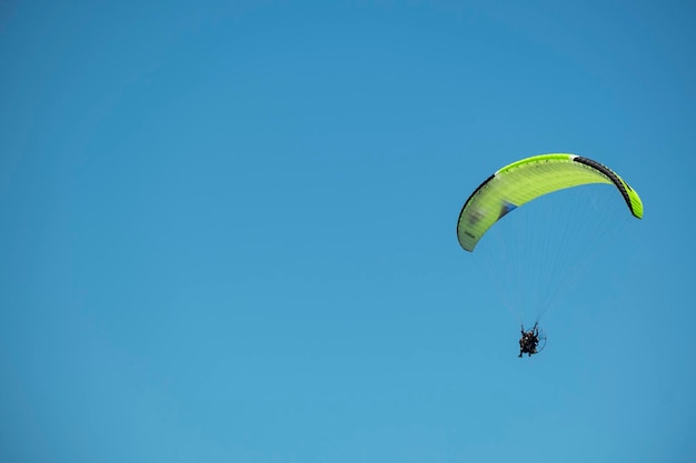 Parapente voando em dia ensolarado com céu azul