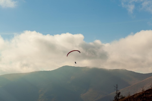 Parapente voando sobre nuvens em dia de verão