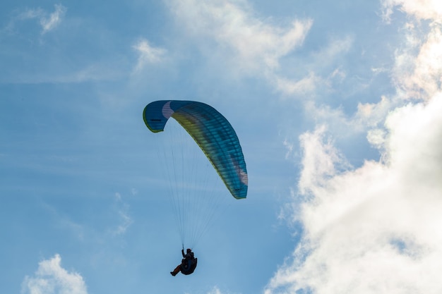 Parapente voando sobre nuvens em dia de verão