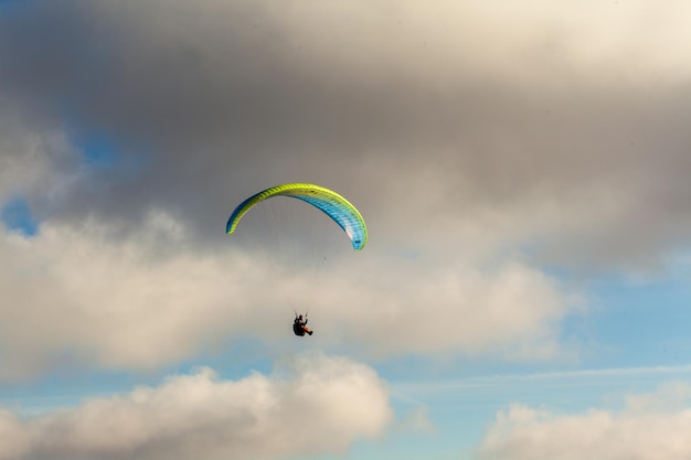 Parapente voando sobre nuvens em dia de verão