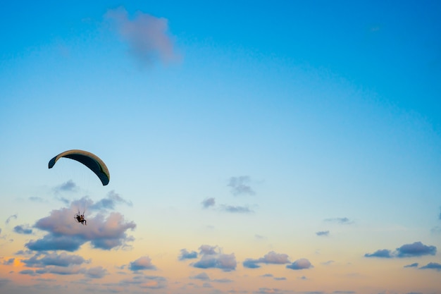 Parapente volando en el cielo al atardecer