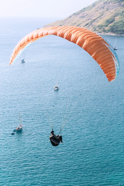 Parapente volando sobre el mar en un día soleado