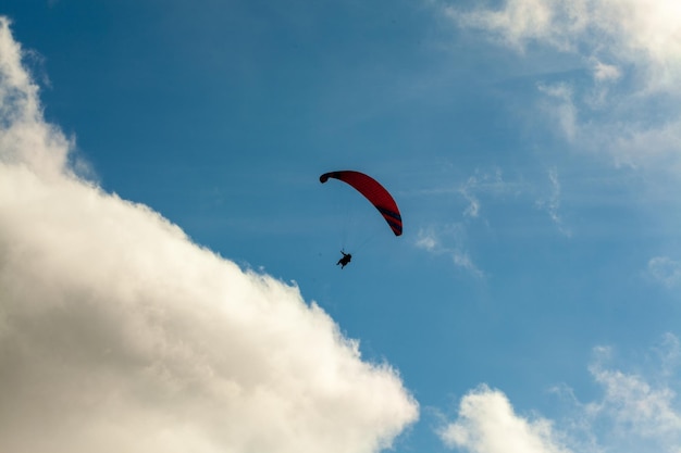 Parapente volando sobre las nubes en el día de verano