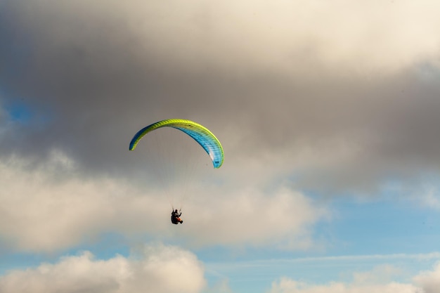 Parapente volando sobre las nubes en el día de verano