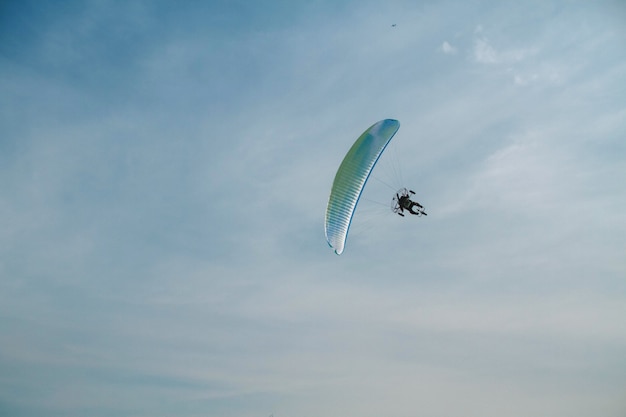 El parapente vuela sobre el cielo azul claro.