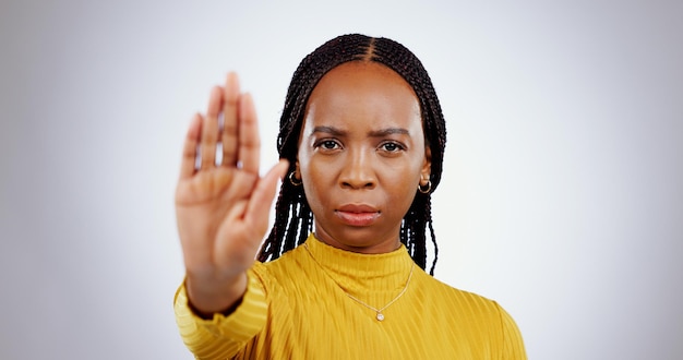 Foto parar mão mulher negra e retrato zangado com protesto cautela e sinal de palma em um estúdio aviso fundo branco e séria pessoa feminina africana com recusa rejeição e gesto proibido