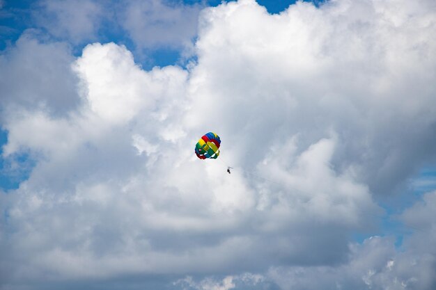 Foto parasailing gegen die regenbogenfarben des blauen himmels