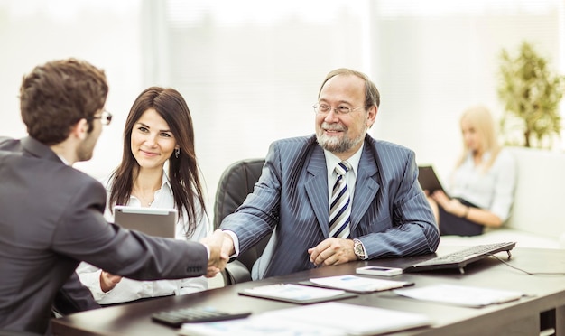 Parceiros de negócios de aperto de mão após discussão dos termos financeiros do novo contrato