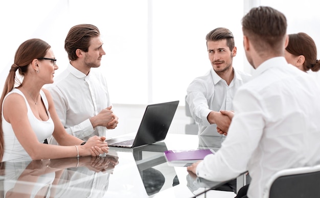 Parceiros de negócios de aperto de mão sobre a mesa