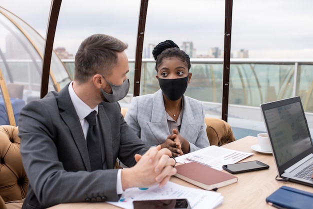 Parceiros de negócios interculturais contemporâneos discutindo dados financeiros