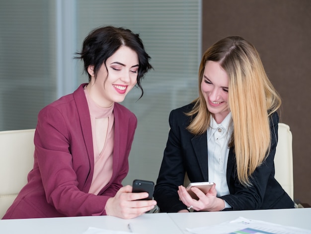 . parceiros de negócios ou colegas discutindo algo no telefone celular.