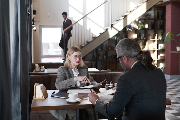 Foto parceiros de negócios sentados à mesa e discutindo um novo projeto durante uma reunião no restaurante