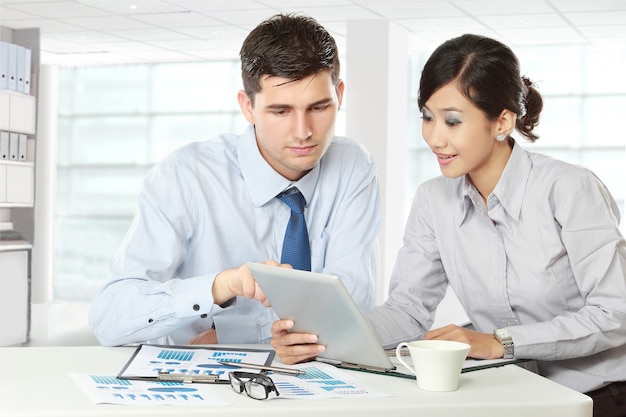 Parceiros de negócios usando o touchpad na reunião