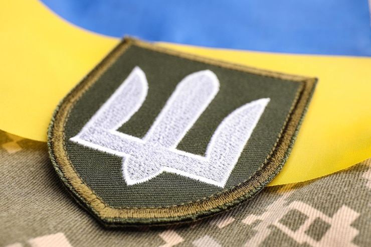 Foto parche militar y bandera ucraniana en primer plano de camuflaje de píxeles