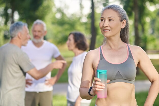 Parecendo em forma. uma mulher desportiva com uma garrafa de água nas mãos