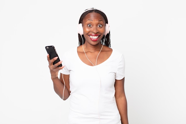 Parecendo feliz e agradavelmente surpreso com fones de ouvido e um smartphone