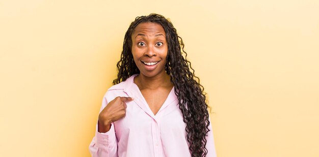 Parecendo feliz, orgulhoso e surpreso, apontando alegremente para se sentir confiante e elevado