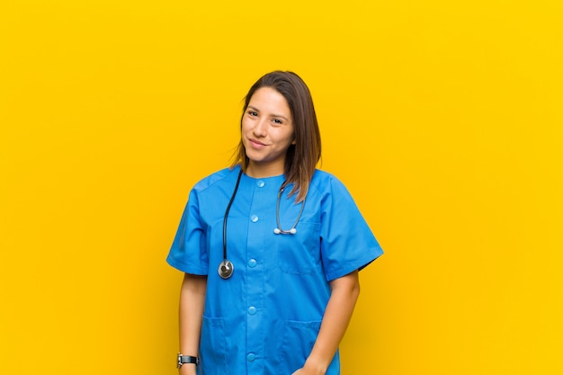 Foto parecendo orgulhoso, confiante, legal, atrevido e arrogante, sorrindo, sentindo-se bem-sucedido isolado contra parede amarela