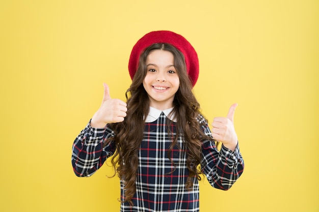 Parecendo perfeito como usar vestido xadrez menina cabelo longo e encaracolado após a visita ao cabeleireiro moda adolescente feliz de uniforme de volta à escola menina pequena aparência elegante criança parisiense boina francesa