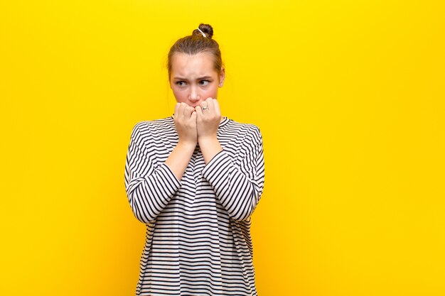 parecendo preocupado, ansioso, estressado e com medo, roendo unhas e olhando para o espaço lateral da cópia