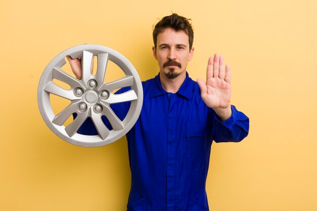 Foto parecendo sério mostrando a palma aberta fazendo gesto de parada conceito de reparador de carro