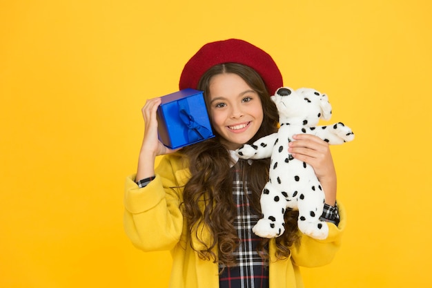 Parecendo uma boa garota parisiense com brinquedo de cachorro e caixa de presente pequena lembrança da frança menina na moda boina francesa feliz aniversário tempo de compras melhor dia de sempre feliz saudação de férias