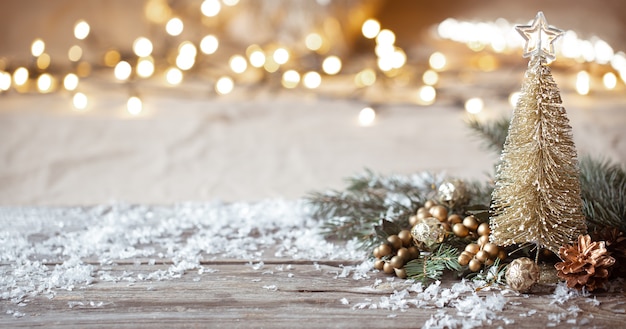 Pared acogedora de invierno con detalles de decoración festiva, nieve en una mesa de madera y bokeh. El concepto de un ambiente festivo en casa.