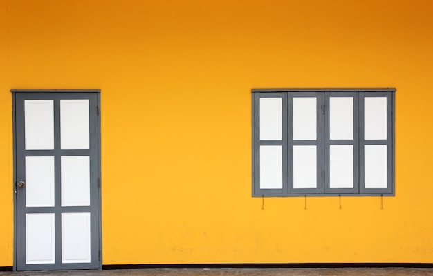 Foto la pared amarilla con puerta y ventanas