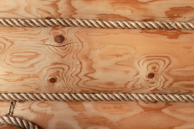 Pared de una casa de troncos de madera decorada con cuerda.