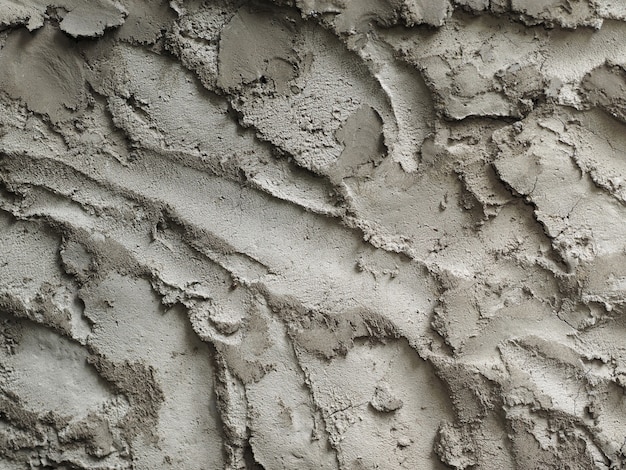 Una pared de cemento gris con una textura muy rugosa.