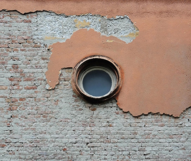 Pared despegada dañada y fondo de ladrillos para restauración