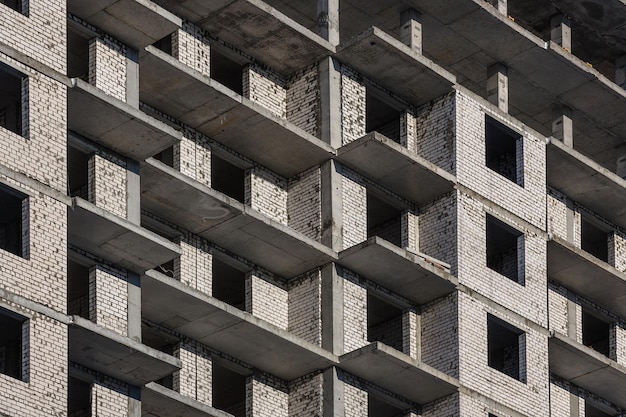 La pared de un edificio de ladrillos en construcción Ventanas y balcones de un nuevo edificio de apartamentos