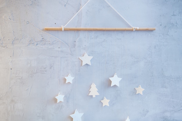 La pared está decorada con una rama de árbol con estrellas, decoración de materiales ambientales.