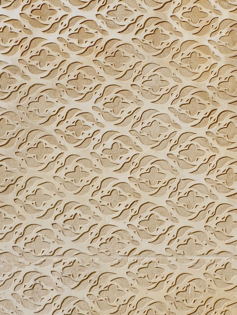 Pared de estuco beige realizada en técnica de esgrafiado con ornamentación floral en el centro del distrito de Toledo España