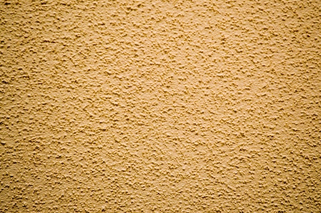 Pared de fondo de textura de estuco decorativo de construcción en relieve áspero amarillo
