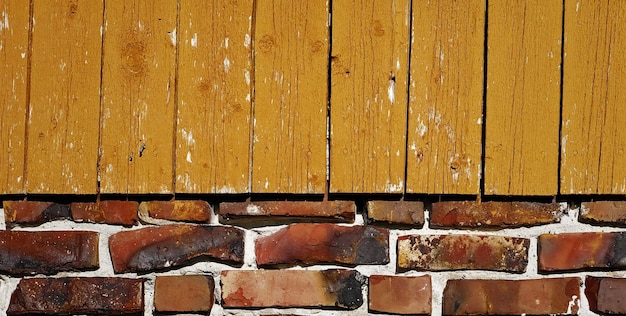 Una pared de ladrillo amarillo con una tabla de madera que dice ladrillo.