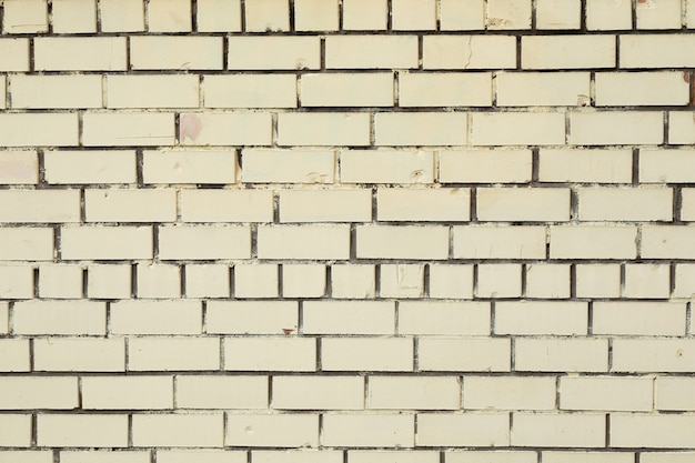 Pared de ladrillo blanco sucio con hormigón gris oscuro en los huecos